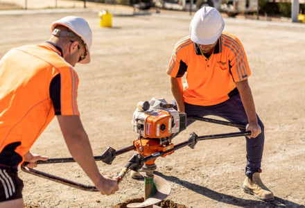 Construction workers digging at a construction site with excavators.